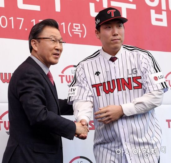 프로야구 LG 김현수가 21일 서울 삼성동 그랜드 인터컨티넨탈호텔에서 열린 입단식에서 신문범 대표이사에게 유니폼과 모자를 전달 받고 있다. 2017.12.21.김현민 기자 kimhyun81@asiae.co.kr