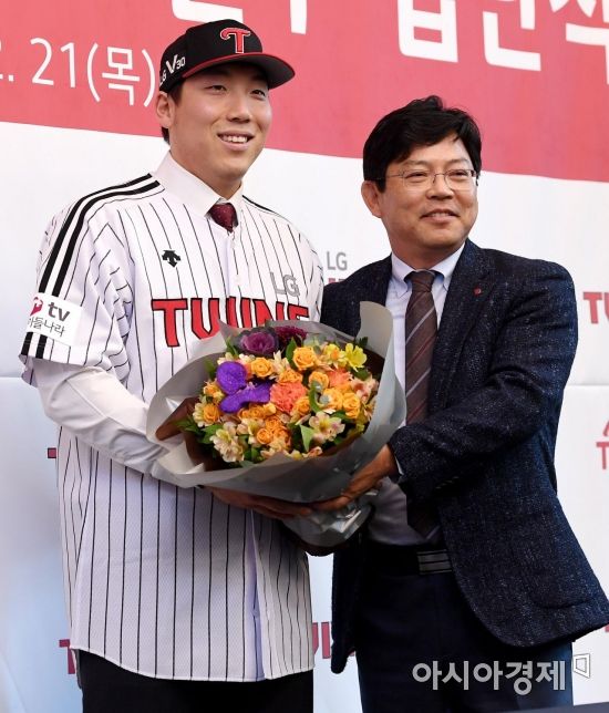 프로야구 LG 김현수가 21일 서울 삼성동 그랜드 인터컨티넨탈호텔에서 열린 입단식에서 양상문 단장으로부터 축하 꽃다발을 받고 있다. 2017.12.21.김현민 기자 kimhyun81@asiae.co.kr