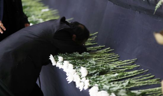 제천 복합스포츠센터 화재 참사로 아내를 잃은 한 유가족이 24일 제천체육관에 마련된 합동분향소 국화에 얼굴을 묻고 눈물을 흘리고 있다./사진=연합뉴스