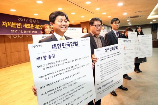 김영배 성북구청장을 비롯해 구 간부와 36개 부서 직원 400여명이 참여해 헌법 전문과 10장 130개조를 부서별로 나눠 직원들이 직접 손 글씨로 종이에 필사 후 기념 사진을 찍고 있다.