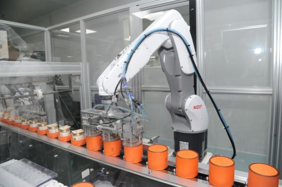 코스나인 공장 충전실에 있는 자봉화 로봇이 완성된 화장품을 케이스에 넣는 작업을 하고 있다.