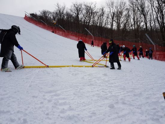 평창올림픽 자원봉사자들이 추위를 막기 위해 레인 코트를 입고 스키 코스에 물을 뿌리고 있다. 이는 선수들이 동일한 환경에서 경기를 할 수 있도록 하기 위한 작업이다.
