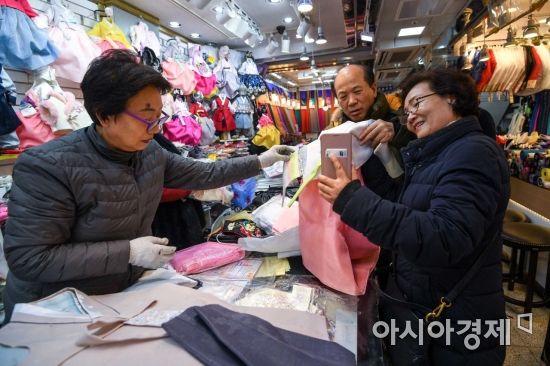 민족 최대 명절 설날을 일주일여 앞둔 7일 서울 종로구 광장시장에 마련된 한복상점에서 한 시민이 손녀에게 전달할 한복을 고르고 있다./강진형 기자aymsdream@