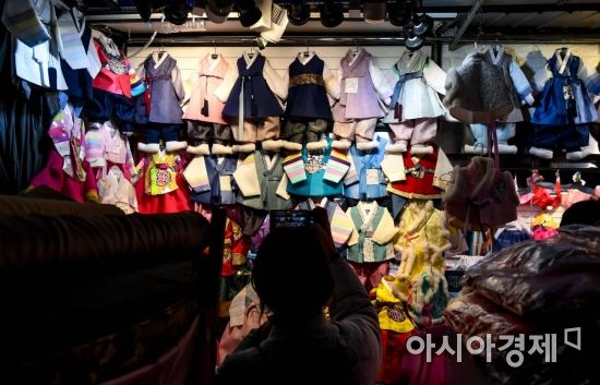 민족 최대 명절 설날을 일주일여 앞둔 7일 서울 종로구 광장시장에 마련된 한복상점에서 한 시민이 어린이 한복을 휴대전화로 촬영하고 있다./강진형 기자aymsdream@
