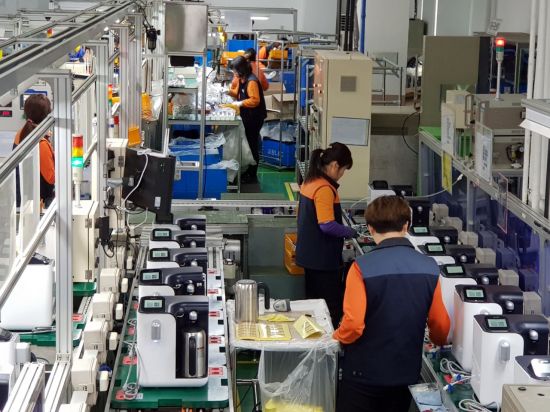 교원그룹 인천공장 생산직원들이 지난 9일 '웰스 포트 100도 정수기' 제조공정에 맞춰 작업을 하고 있다.