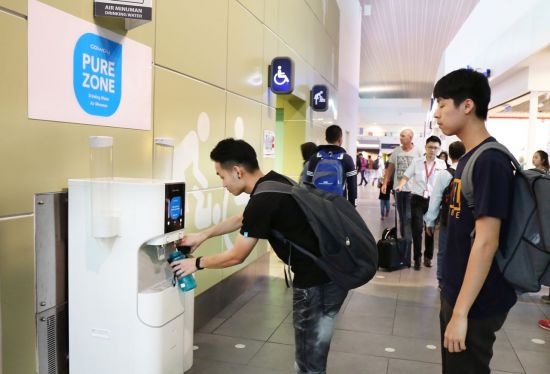 말레이시아 쿠알라룸푸르국제공항 이용객이 '코웨이 정수기 체험 퓨어 존'에서 물을 담고 있다.