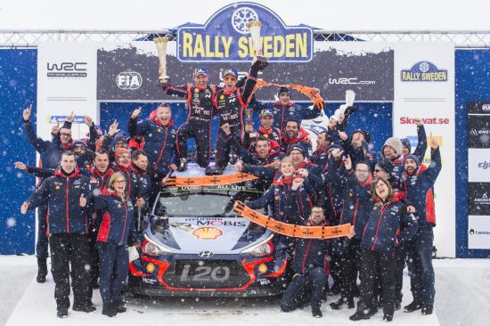 2018 WRC 스웨덴 랠리 시상대에서 현대 월드랠리팀 선수 및 관계자들의 기념사진. 신형 i20 랠리카 위에서 니콜라스 질술(왼쪽)과 티에리 누빌이 우승컵을 들고 환호하고 있다.