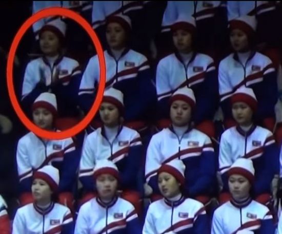 한 북한 응원단원이 미국 선수의 등장에 박수를 치자 옆자리의 동료가 팔꿈치로 툭툭 치며 하지 말라는 신호를 주고 있다.(유튜브 캡처)