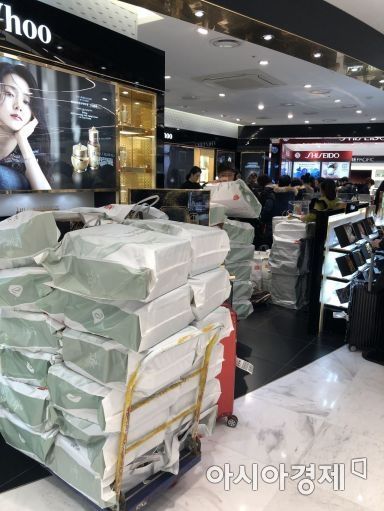 한 서울 시내 면세점. 인기 브랜드 화장품 매장 앞에 중국인 보따리상 전달용 상품이 쇼핑백에 담겨 쌓여 있다.