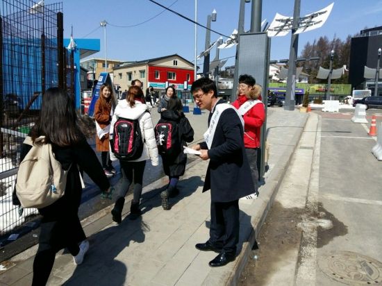 교육부 직원들이 평창 올림픽파크 인근 횡계로터리에서 장애인식개선 캠페인을 안내하는 홍보 리플릿을 나눠주고 있다.