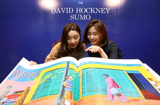 1일 오전 현대백화점 무역센터점 9층 오픈 도서관에서 직원들이 영국의 팝아트 화가 '데이비드 호크니'의 작품이 담긴 대형 책을 보고 있다.