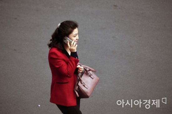 [포토] 휴대전화로 통화하며 걷는 북한 여성