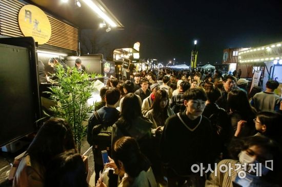 서울 여의도 한강공원에서 열린 밤도깨비야시장을 찾은 시민들이 푸드트럭 음식을 즐기며 나이트마켓을 둘러보고 있다./강진형 기자aymsdream@