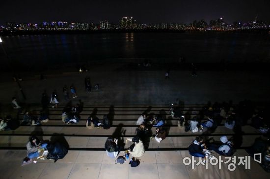 서울 여의도 한강공원에서 열린 밤도깨비야시장을 찾은 시민들이 강변에 앉아 푸드트럭 음식을 먹고 있다./강진형 기자aymsdream@