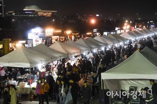 서울 여의도 한강공원에서 열린 밤도깨비야시장에 참여한 푸드트럭과 나이트마켓이 밤하늘을 밝히고 있다./강진형 기자aymsdream@