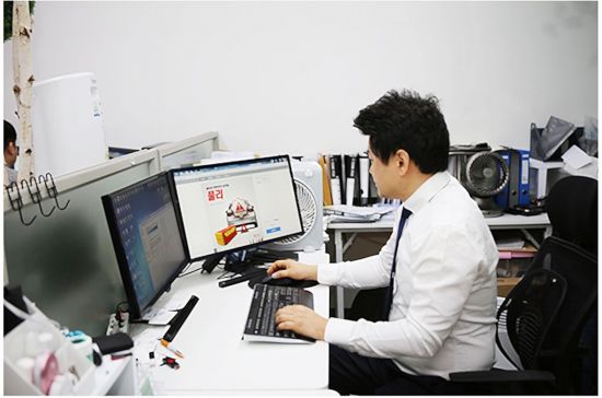 김원석 브링유 대표가 경기도 수원에 위치한 사무실에서 일을 하면서 안전 우산삼각대 '풀리' 제품 소개가 나온 컴퓨터 화면을 보고 있다.