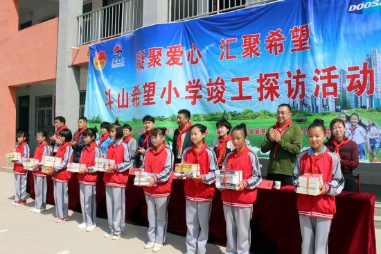 두산인프라코어가 최근 중국 산둥성 허쩌시에서 두산희망소학교 준공식을 열고 학생들에게 도서와 체육용품을 전달했다. [사진= 두산인프라코어 제공]
