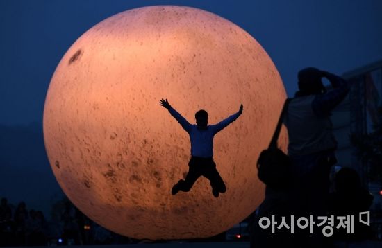 5월14일 서울 광화문광장에서 시민들이 지름 5.5m 크기의 대형 보름달 ‘만천명월’을 배경으로 실루엣 사진을 찍고 있다. /김현민 기자 kimhyun81@