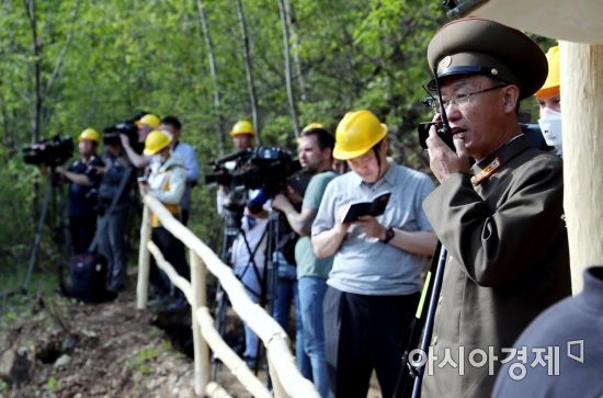 24일 북한 핵무기연구소 관계자들이 함경북도 길주군 풍계리 핵실험장 폐쇄를 위한 폭파 작업을 했다. 핵무기연구소 관계자가 갱도 폭파에 앞서 무선 교신을 하고 있다./사진공동취재단