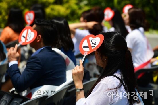 세계 금연의 날인 31일 서울 종로구 세종로공원에서 한국금연운동협의회 주최로 열린 기념식에서 참석자들이 금연 로고가 새겨진 부채로 햇볕을 가리고 있다. 매년 5월 31일은 세계보건기구(WHO)가 창립 40주년을 맞아 담배 연기 없는 사회를 만들기 위해 지정한 날이다. /문호남 기자 munonam@
