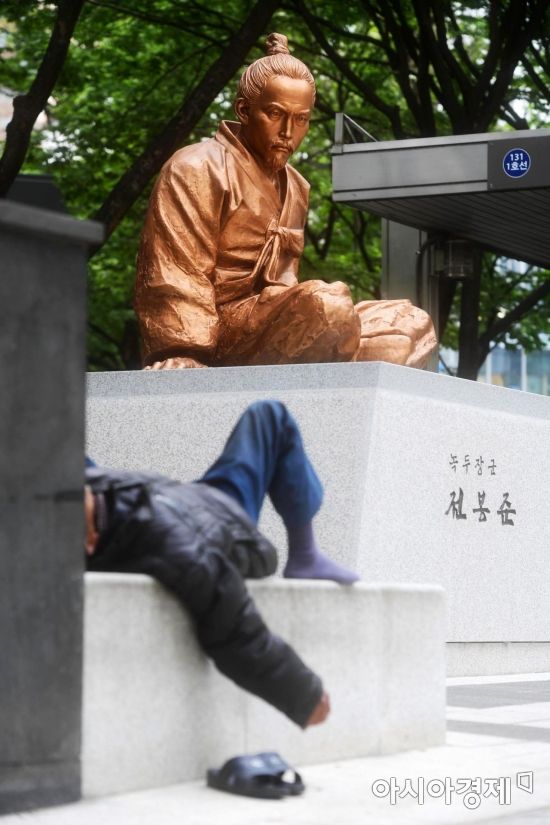 지난 4월 24일, 서울 종로 네거리에 순국 123년 만에 세워진 녹두장군 전봉준 동상 근처에 술에 취한 노숙인이 잠을 자고 있다. 행인들은 악취에 코를 막은 채 발걸음을 재촉했다. /문호남 기자 munonam@
