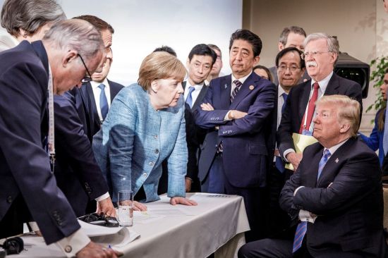 ▲앙겔라 메르켈 독일 총리가 지난 9일(현지시간) 캐나다 퀘벡주 샤를부아에서 열린 주요 7개국(G7) 정상회의 이틀째 회의에서 팔짱을 끼고 앉아 있는 도널드 트럼프 미국 대통령을 내려다보고 있다. [이미지출처=연합뉴스]