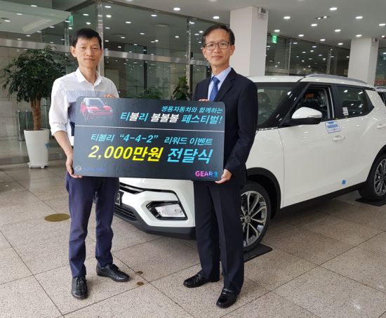 박세홍 쌍용차 경인지역본부장(오른쪽)이 2000만원 페이백 행운의 주인공이 된 권영욱 씨에게 경품을 전달하고 있다.