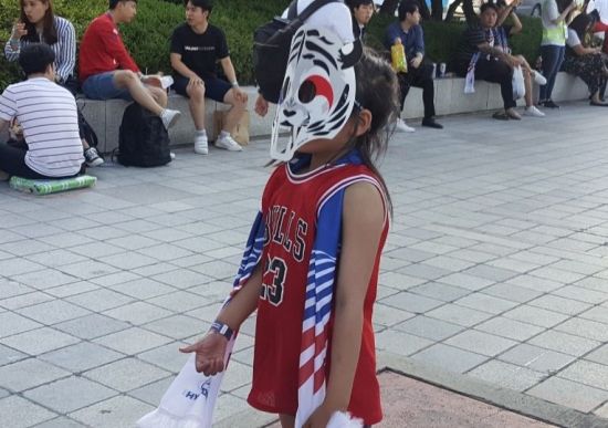 '붉은악마'로 변신한 어린아이가 스웨덴전을 앞두고 한국 축구 대표팀을 응원하기 위해 거리로 나왔다. (사진=이승진 기자)