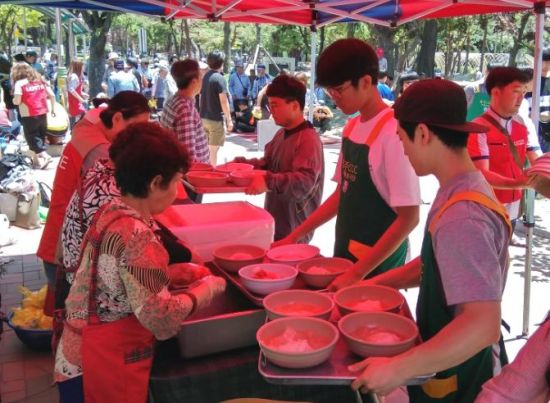 롯데푸드 샤롯데봉사단이 청주 중앙공원에서 지역 어르신들을 위한 무료 급식 봉사를 진행하고 있다.