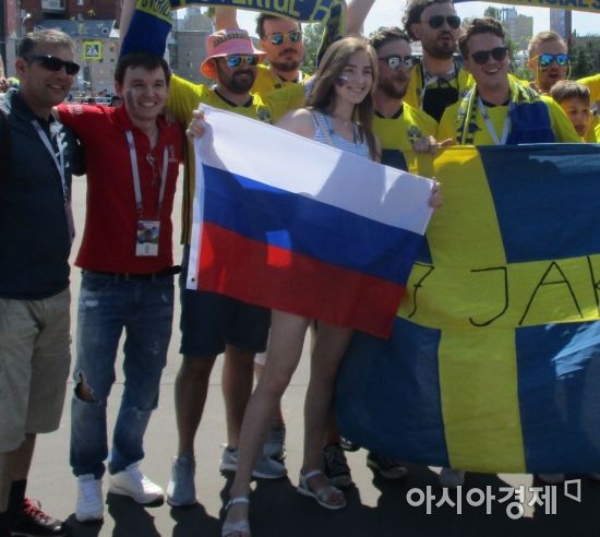러시아 니즈니노브고로드 스타디움 인근에서 스웨덴 팬들과 사진찍는 러시아 여성 축구팬 [사진=김형민 기자]