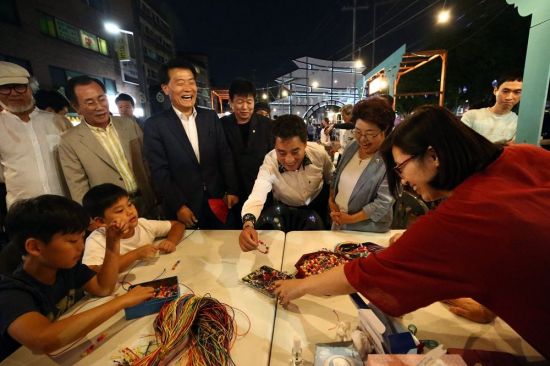 2018 성북동 문화재 야행’에서 매듭 팔찌 만들기 체험 프로그램을 진행하고 있는 매듭기능 전승자 박진영씨(오른쪽 첫 번째)와 이승로 성북구청장 당선인(왼쪽에서 세번째)