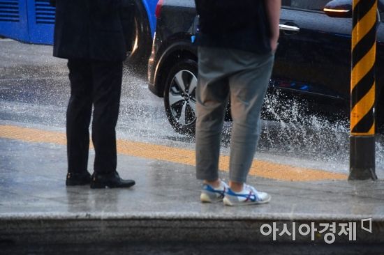 전국에 장맛비가 내린 26일 서울 종로구 광화문 네거리에서 한 차량이 물웅덩이를 지나며 빗물을 튀기고 있다. /문호남 기자 munonam@