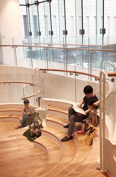 ▲남편과 딸이 도서관 계단에 앉아 책을 읽고 있다. '소리가 허용되는 공간'이라 부모가 아이에게 책을 직접 읽어줄 수 있다는 것이 장점이다.