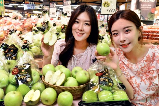 모델들이 19일 서울 등촌동 홈플러스 강서점에서 ‘썸머킹 사과’(국내산/5~9입/7990원)를 선보이고 있다.