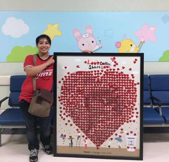 지원 대상자인 필리핀 다문화가정의 안자 어머니가 지난해 7월 임직원들의 캠페인 참여로 꽉 찬 스티커판을 들고 기뻐하는 모습
