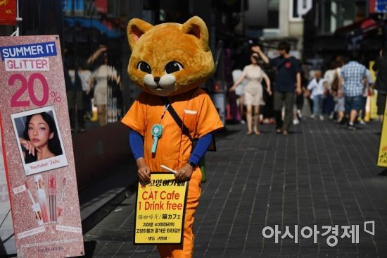 폭염이 기승을 부리고 있는 지난달 19일 서울 명동거리에서 인형탈을 쓴 아르바이트생이 호객행위를 하고 있다. 알바생의 목에 휴대용 선풍기가 걸려 있다. /문호남 기자 munonam@