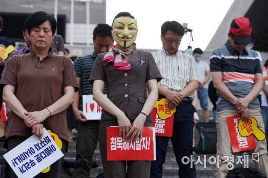 아시아나항공 직원들이 20일 서울 종로구 세종문화회관 앞에서 'OZKA면(오죽하면) 이러겠니' 4차 집회를 열고 숨진 기내식 협력업체 대표에 대한 묵념을 하고 있다. /문호남 기자 munonam@