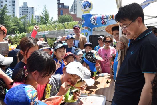 오승록 노원구청장이 21일 당현천 물축제 수박빨리먹기 대회에 참여한 어린이들을 지켜보고 있다.