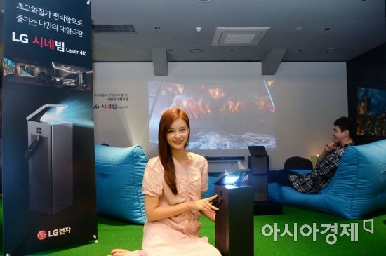 ▲LG전자 모델이 서울 용산구 한강대로에 위치한 CGV 용산아이파크몰 상영관에서 'LG 시네빔' 프로젝터 체험존을 소개하고 있다. (제공=LG전자)