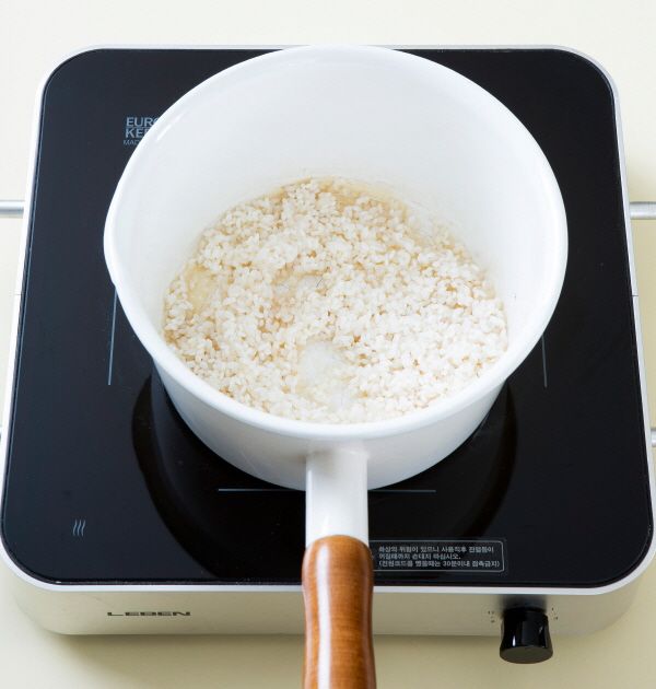3. 냄비에 참기름을 두르고 불린 쌀을 넣어 3분 정도 볶는다. 애호박, 양파, 당근을 넣어 2분 정도 볶다가 물 3~4컵을 넣어 끓인다.