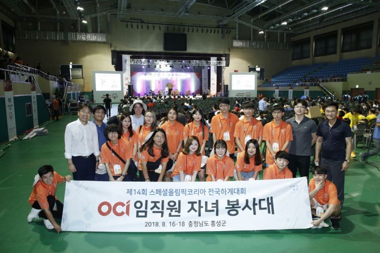 OCI 사회공헌실 오창우 상무(뒷줄 오른쪽 첫 번째)와 15명의 OCI 임직원 자녀들이 16일 충남 홍성에서 열린 제 14회 한국스페셜올림픽대회에서 기념사진을 찍고 있다.  [사진= OCI 제공]