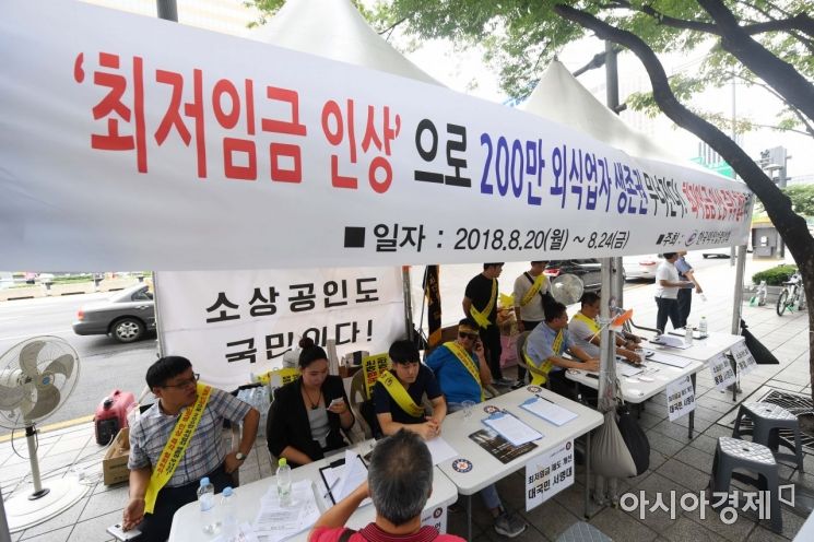 한국외식업중앙회 관계자들이 20일 서울 종로구 광화문광장에서 열린 제1차 최저임금 인상 규탄집회를 마친 뒤 최저임금 제도개선을 촉구하는 서명을 받고 있다. 이들은 "최저임금의 급격한 인상이 영세 자영업자에게는 사실상 사형 선고"라며 "정치권과 정부가 자영업자 생존권 보장을 위한 종합 대책을 마련해 달라"고 요구했다. /문호남 기자 munonam@
