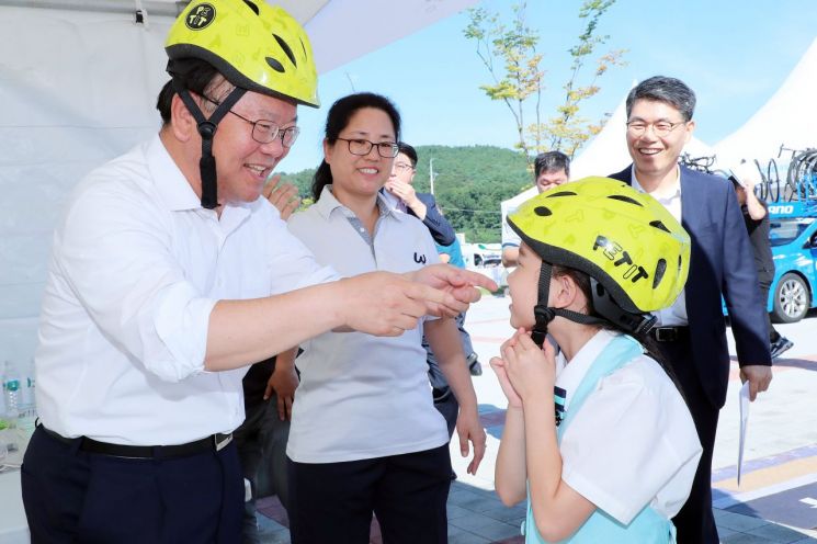 지난달 31일 강화도에서 열린 자전거대회에서 김부겸 행정안전부 장관이 어린이와 함께 안전모 체험을 하고 있다. 사진제공=행정안전부