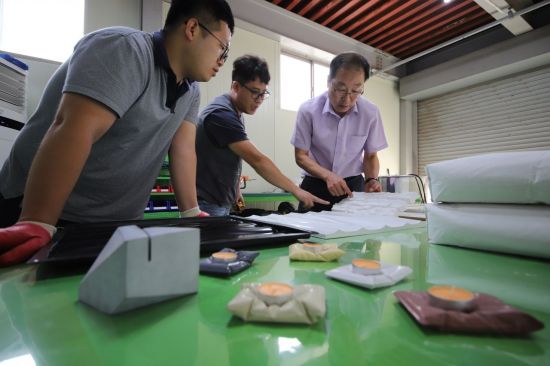 윤기원 아주기술연구소 소장(오른쪽)과 직원들이 상온양생 초고성능 콘크리트 조성물인 '콘크리트 랩'을 활용해 만든 인테리어 소품들을 보고 있다.