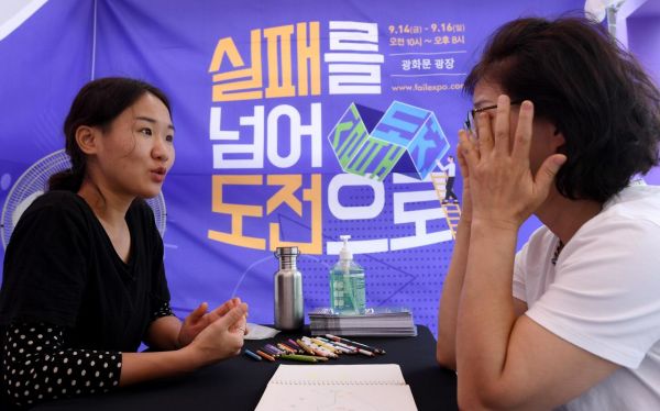 서울 광화문광장에서 '실패를 넘어 도전으로'라는 주제로 열린 '2018 실패박람회'를 찾은 한 시민이 실패 공감 상담을 받으며 눈물을 훔치고 있다./김현민 기자 kimhyun81@