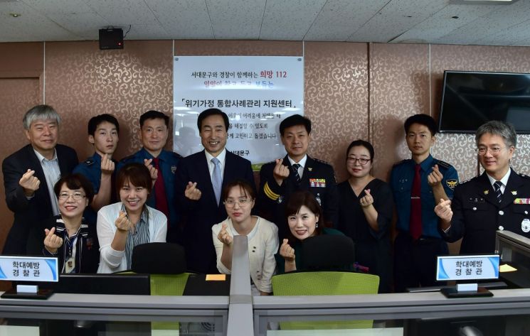 문석진 서대문구청장(뒷줄 왼쪽 네 번째)과 고범석 서대문경찰서장(뒷줄 왼쪽 다섯 번째)이 구청 복지정책과 내에 설치된 ‘위기가정 통합사례관리 지원센터’에서 통합사례관리사, 학대예방경찰관(APO), 상담인력 등과 함께 손가락 하트를 만들어 보이고 있다.