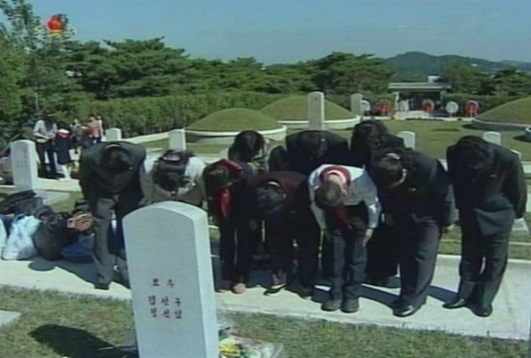 조선중앙 TV가 추석을 맞아 북한의 각계층 근로자와 유가족들이 인민군 영웅열사묘를 찾아 성묘하고 있는 모습을 보도한 모습