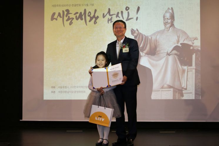 세계어린이한글손글씨대회 특선상을 시상한 신홍섭 KB저축은행 대표와(사진 오른쪽) 수상자인 이서현 학생이 기념 촬영을 하고 있다.