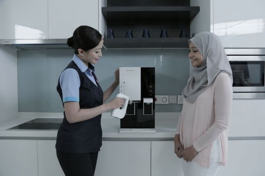 코웨이 서비스 전문가인 말레이시아 코디(왼쪽)가 고객에게 제품 관리 등에 대해 설명하고 있다.