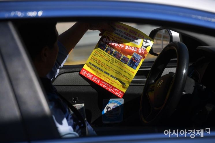 [포토]택시 생존권 사수 결의대회 홍보 전단지 보는 택시기사